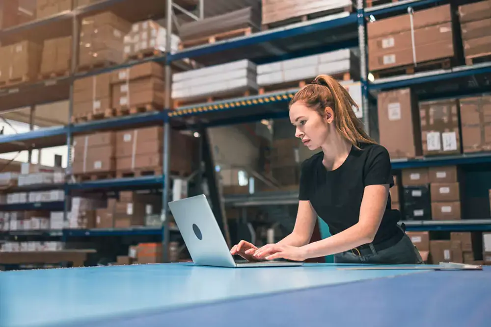 Woman using a laptop in a warehouse