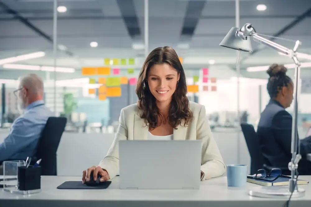 Young, smiling businesswoman working on Project Portfolio Management in modern office.